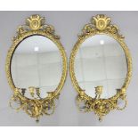 PAIR OF GILT GESSO GIRONDOLES, 19th century, the oval plate beneath a shield and scrolling crest and