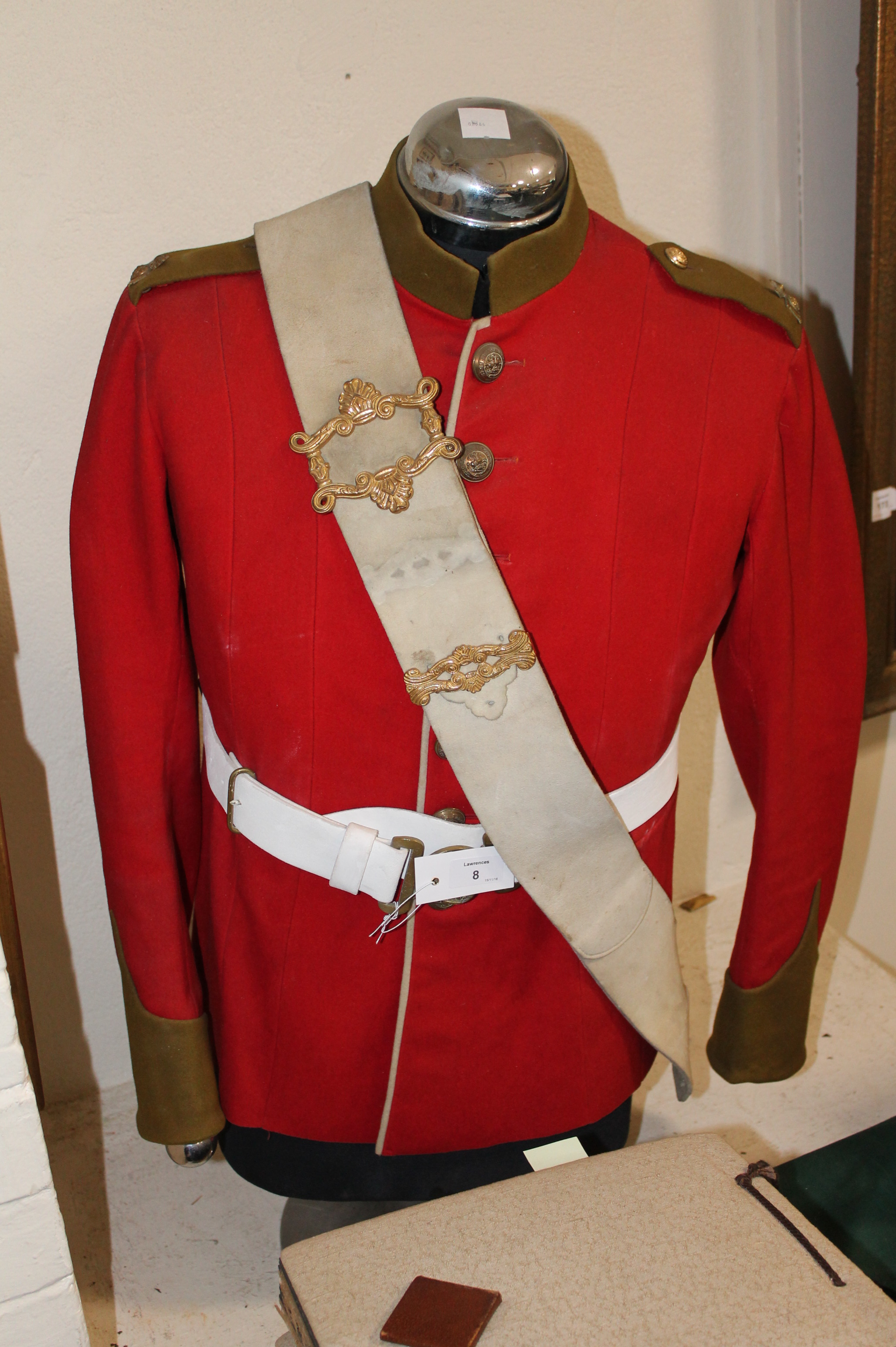 A NORTHUMBERLAND FUSILIERS TUNIC ON STAND. A other ranks red tunic with kahki cuffs and collar.