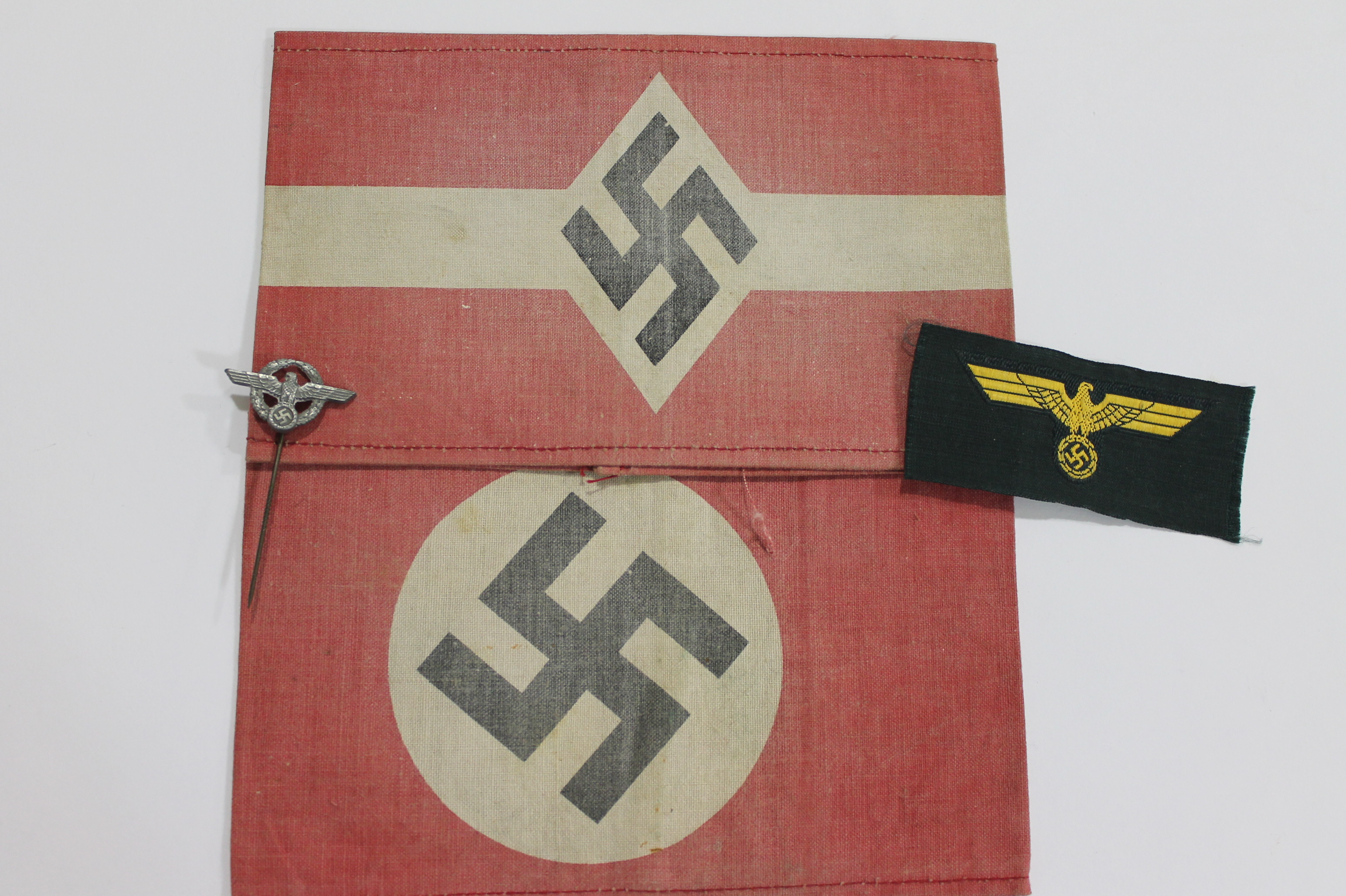 GERMAN ARMBANDS. Two German Armbands with faded red backgrounds, one with a Swaztika the other