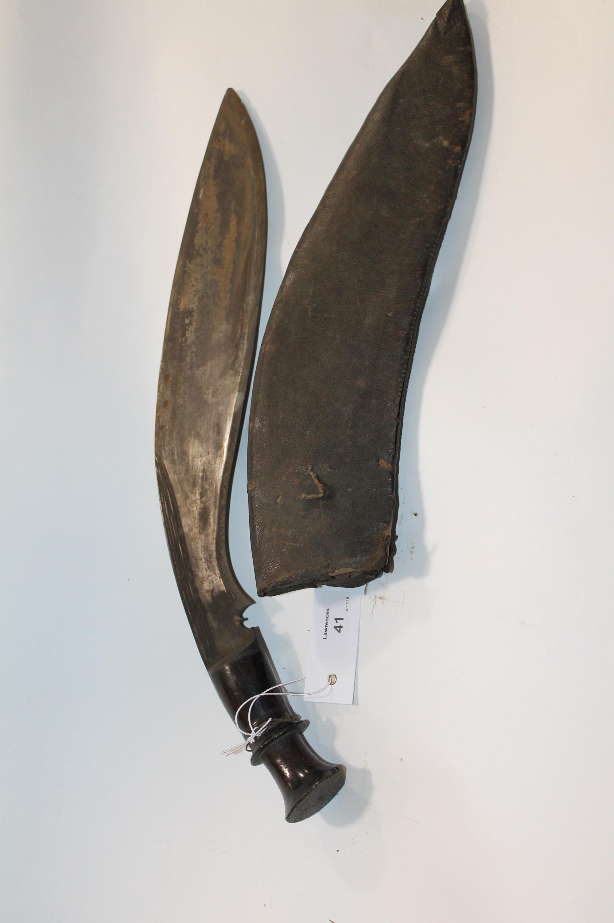 A KUHKRI A 19th/20thC fighting Kuhkri, complete with its sheath. A heavy stained three fullered