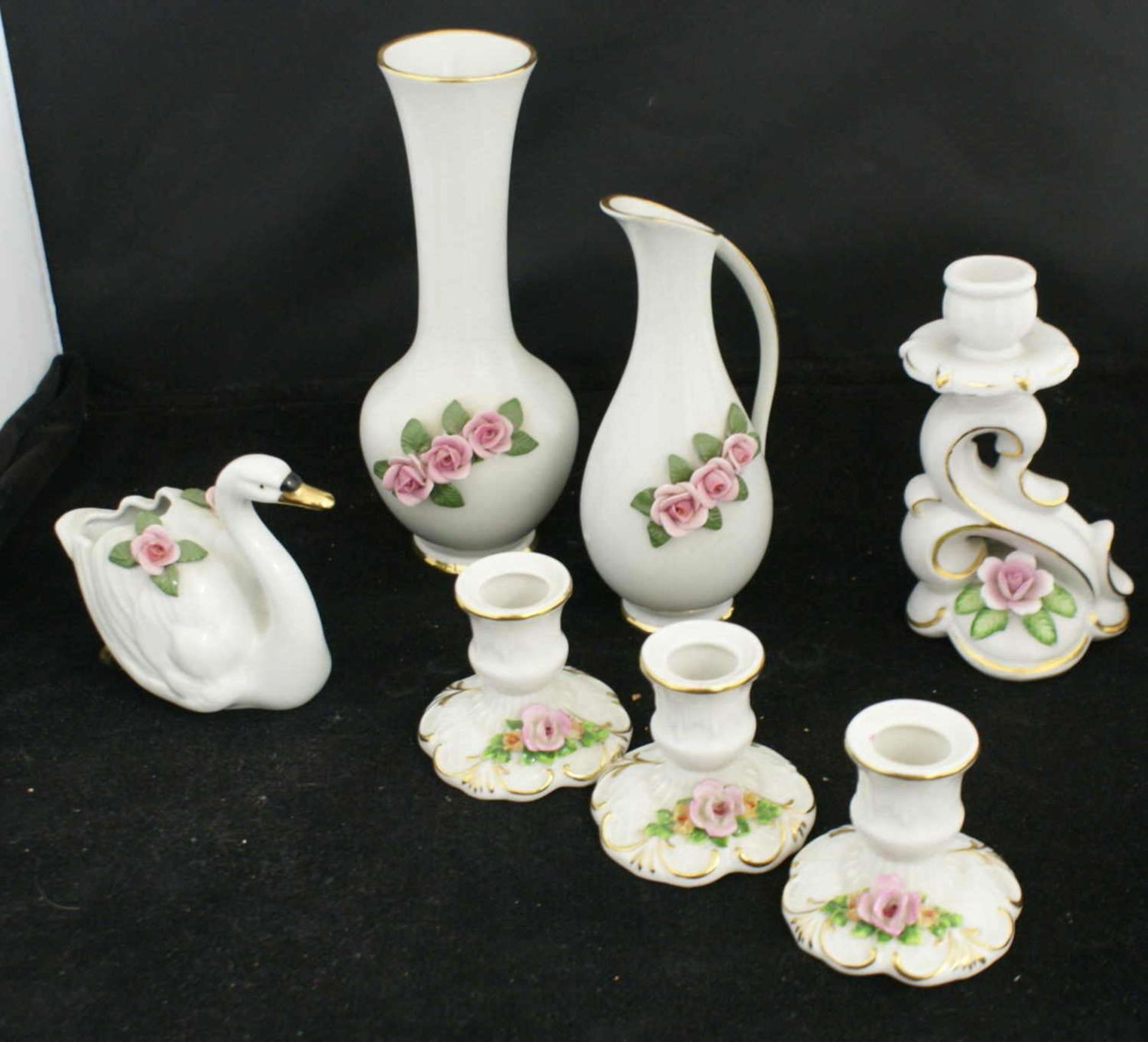 Porzellankonvolut, bestehend aus 1 Vase, 1 Henkelvase, 4 Kerzenständer, sowie 1 Schwan. Alles