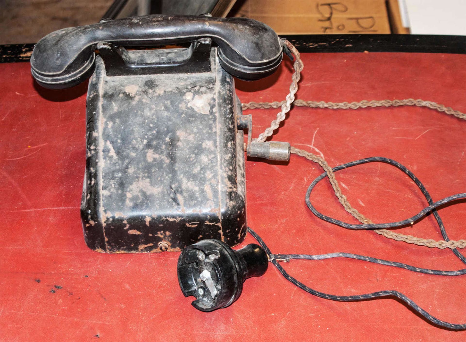 Uraltes Metall Telefon mit Bakelit Hörer. Rest aus Metall, mit Kurbel. Starke Gebrauchspuren.Ancient