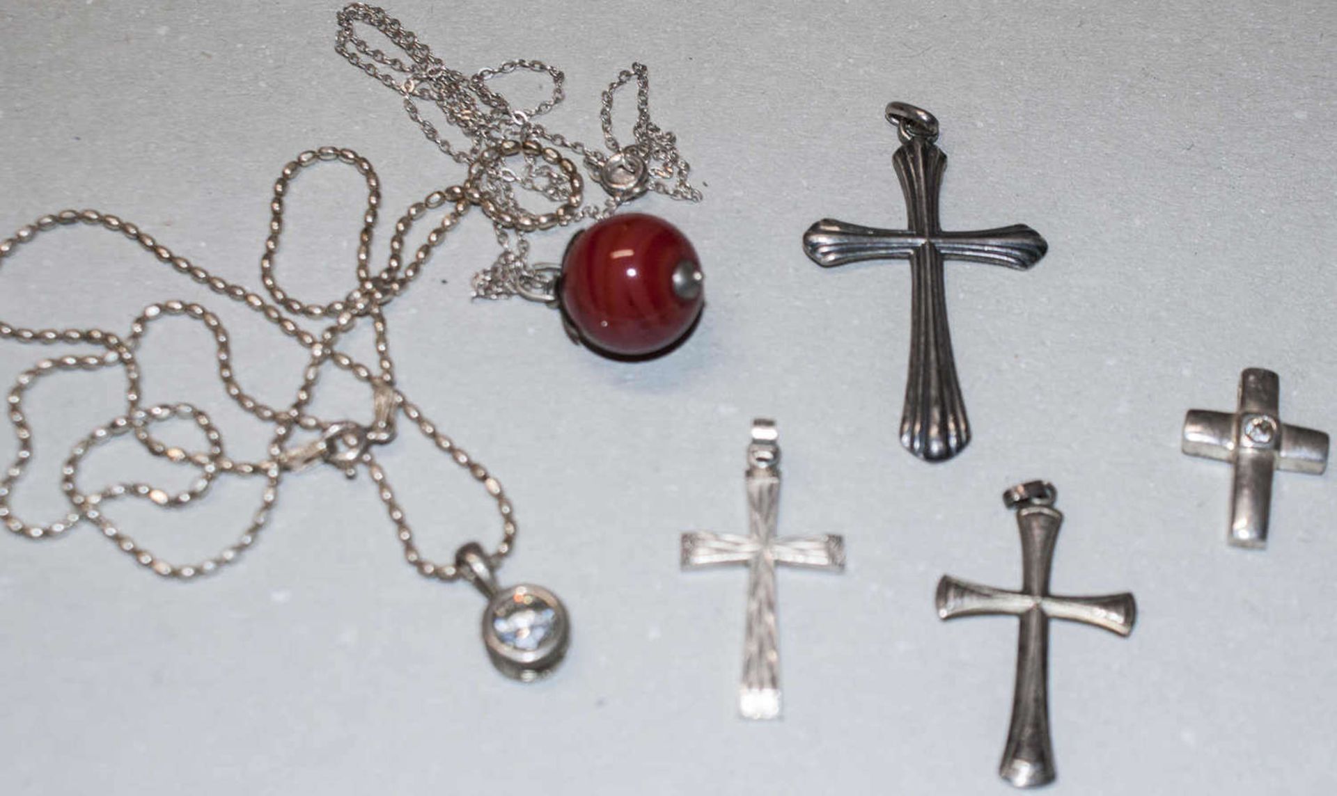 Lot Silberschmuck, dabei 2 Ketten mit Anhängern, sowie 4 Anhänger "Kreuz", Gewicht ca. 21,6g.Lot