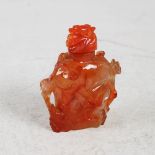 A Chinese carnelian snuff bottle and stopper, the bottle carved with birds, flowers and foliage, the