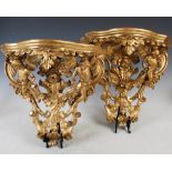 An impressive pair of 19th century giltwood brackets, the serpentine plinths supported by putti