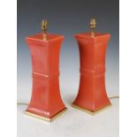 A pair of 20th century coral red ground Chinese style table lamps, on square gilt metal plinths,