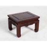 A small Chinese dark wood jardiniere stand, the panelled rectangular top above a frieze carved