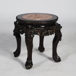 A Chinese dark wood jardiniere stand, Qing Dynasty, the circular top with a mottled red and white