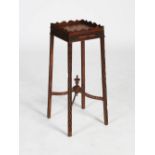 A George III style mahogany urn stand, the square top with a shaped gallery above a blind fret