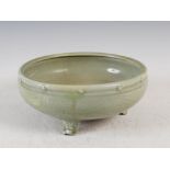 An early Chinese celadon glazed porcelain bowl, probably Ming, with incised foliate and scroll