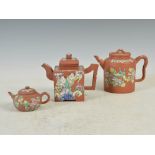 Three Chinese Yixing enamelled teapots and covers, Qing Dynasty, the largest of cylindrical form and