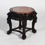 A Chinese dark wood jardiniere stand, Qing Dynasty, the shaped circular top with a mottled red and
