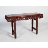 A Chinese dark wood altar table, the rectangular panelled top above a frieze carved with ruyi