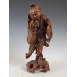 A Chinese carved wood figure of a fisherman, late 19th/early 20th century, with inlaid eyes and