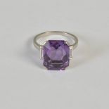 An early 20th century white metal amethyst and diamond three stone ring, centred with a