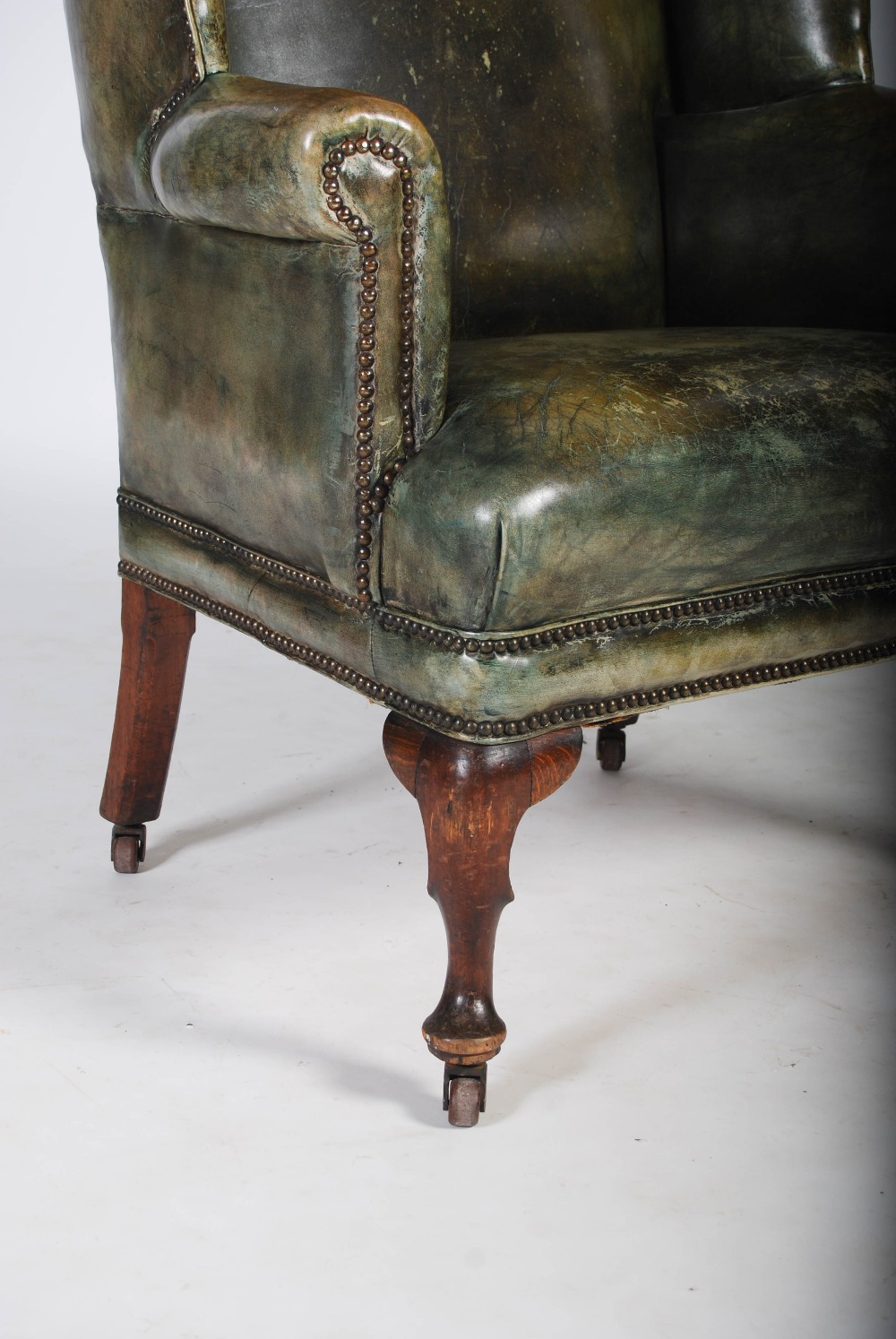 A 19th century oak and green leather upholstered wing armchair, with brass studded detail, raised on - Image 3 of 4