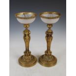 A pair of late 19th/ early 20th century gilt bronze and frosted glass table lamps, the dished