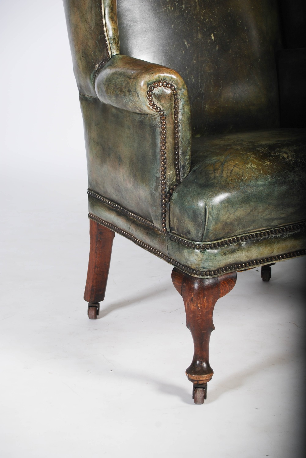 A 19th century oak and green leather upholstered wing armchair, with brass studded detail, raised on - Image 4 of 4