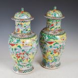 A pair of Chinese porcelain yellow ground jars and covers, Qing Dynasty, decorated with warriors,