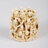 A Japanese ivory netsuke carved with numerous lohan figures, Meiji Period, 5.5cm high x 5cm wide.