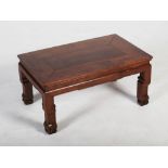 A Chinese dark wood low table, late Qing Dynasty, the rectangular panelled top above a plain frieze,