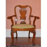 A George III style walnut elbow chair, the shaped top rail above a vase shaped splat with scroll