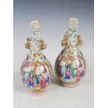 A pair of Chinese porcelain famille rose Canton bottle vases, Qing Dynasty, decorated with panels of