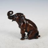 A bronze figure of a kneeling elephant calf, early 20th century, 11.5cm high.