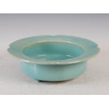 A Japanese celadon glazed bowl, 20th century, with flared rim, raised on three short feet, 31cm