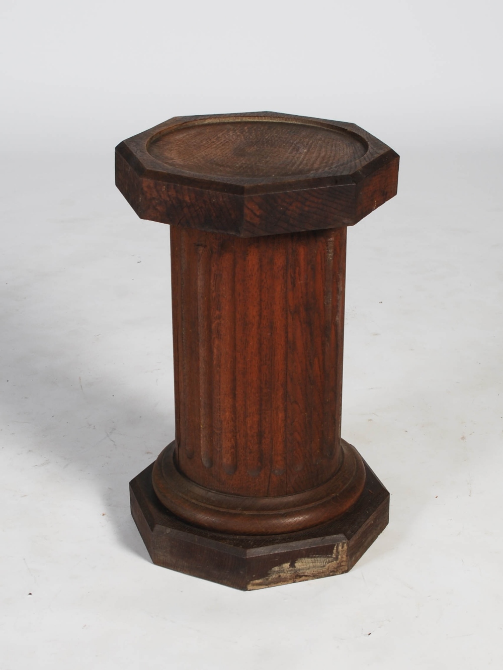 A 20th century oak octagonal plinth in the form of a fluted column, 36cm diameter x 58.5cm high.