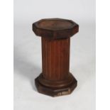 A 20th century oak octagonal plinth in the form of a fluted column, 36cm diameter x 58.5cm high.