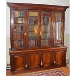 A 19th century mahogany bookcase, the moulded cornice with foliate carved frieze above four glazed