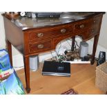 A 19th century mahogany and boxwood lined bow front writing desk, the shaped top with green and gilt