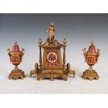 A late 19th century gilt metal and porcelain mounted Egyptianesque clock garniture, the clock with a