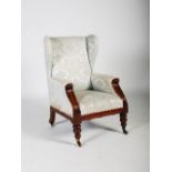 A 19th century mahogany wing armchair, the upholstered back, arms and seat raised on tapered