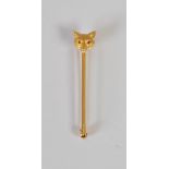 A yellow metal and almandine garnet set fox head stick pin, set with two round cabochon cut