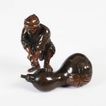 A Japanese bronze figure of a farm worker and gourd, late 19th/ early 20th century, 7.5cm wide x 7.