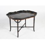 A lacquered papier mache tray top table, the shaped tray with gilded decoration of scrolls and Ho Ho