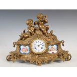 A 19th century porcelain mounted ormolu mantel clock, the circular enamel dial with Arabic and Roman