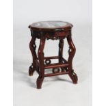 A Chinese dark wood jardiniere stand, late 19th/early 20th century, the shaped circular top with a