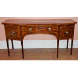 A George III mahogany and boxwood lined bow front sideboard, the shaped rectangular top above a