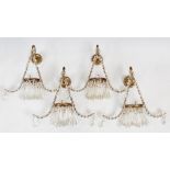 A set of four early 20th century gilt metal and cut glass wall lights, the triangular frames