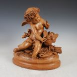 A late 19th/early 20th century terracotta figure group of Cupid and dove, on oval plinth base,