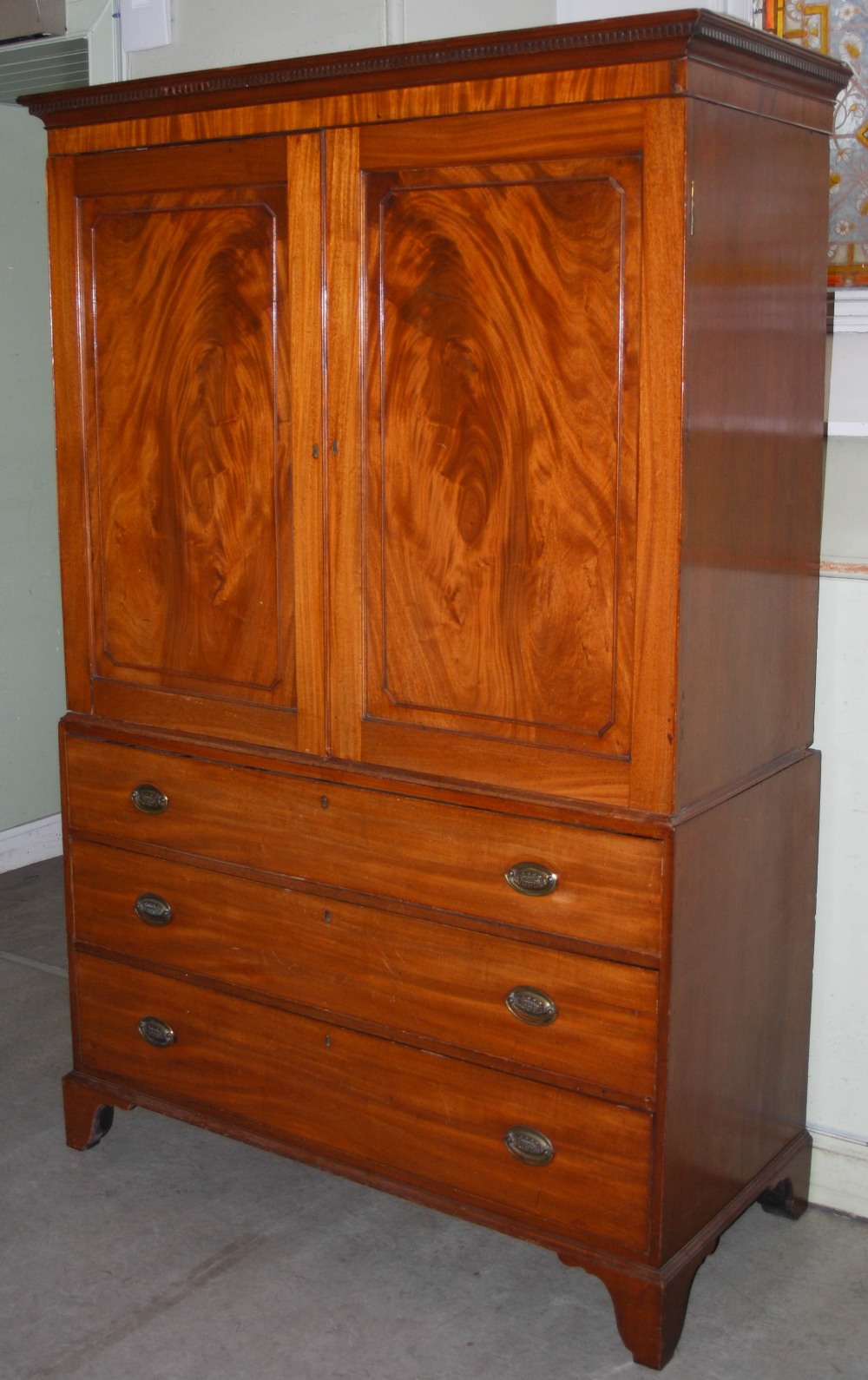 A 19th century mahogany linen press, the moulded cornice and dentil frieze above a pair of