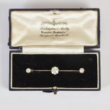 An early 20th century white metal three stone diamond bar brooch, centred with a old cut diamond