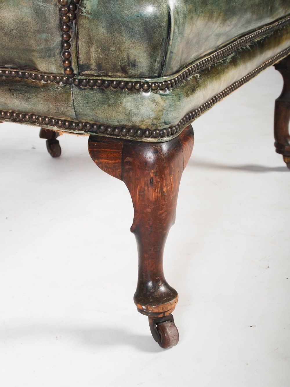 A 19th century oak and green leather upholstered wing armchair, with brass studded detail, raised on - Image 2 of 4