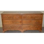 A George III style oak chest, the rectangular top with a moulded edge above six long drawers, raised