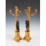 A pair of 19th century bronze and gilt bronze four light candelabra, one cast with a semi clad Roman