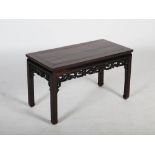 A Chinese dark wood low table, Qing Dynasty, the rectangular panelled top above a scroll carved