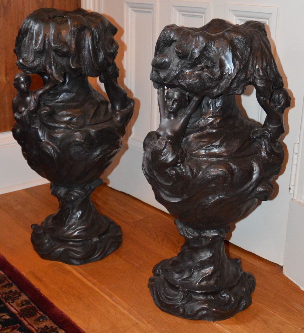 A pair of bronze Art Nouveau style urns, cast with semi clad maidens, 63cm high.